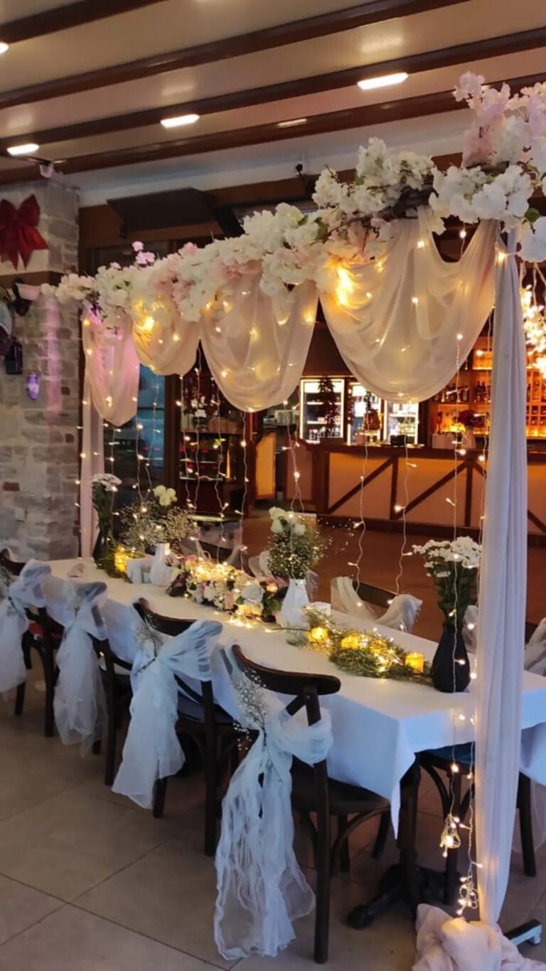 Pembe çiçekli kemerle restoran nişan yemeği masası