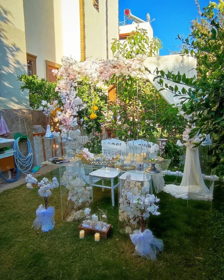 Bahçede pembe beyaz çiçeklerle nişan kurulumu